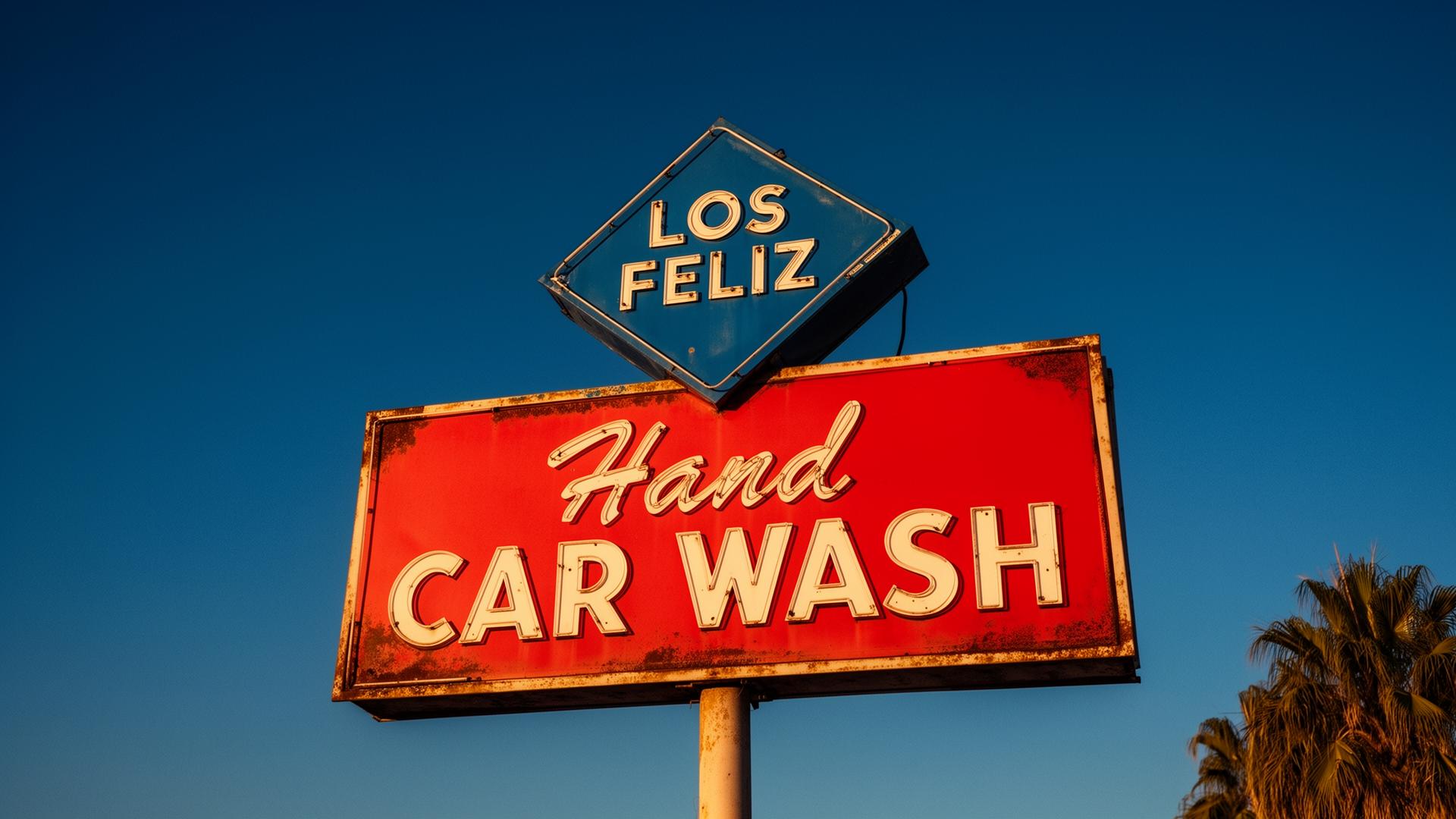 The vintage Los Feliz Car Wash sign — a blue diamond reading 'Los Feliz' above a red 'Hand Car Wash' marquee.